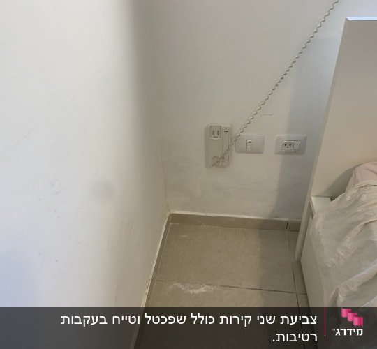 שקעי חשמל על קיר ליד מיטה